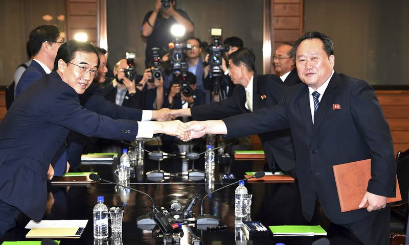 South Korean Unification Minister Cho Myoung-gyon, left, shakes hands with his North Korean counterpart Ri Son Gwon after their meeting at the northern side of Panmunjom in the Demilitarized Zone, North Korea, Monday, Aug. 13, 2018. The rival Koreas announced Monday that North Korean leader Kim Jong Un and South Korean President Moon Jae-in will meet in Pyongyang sometime in September. (Korea Pool/Yonhap via AP)