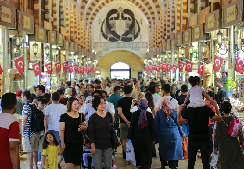 People walk in a market in Istanbul, Monday, Aug. 13, 2018. Turkey's central bank announced a series of measures on Monday to free up cash for banks as the country grapples with a currency crisis. The Turkish lira has nosedived over the past week and tumbled another 7 percent on Monday as the central bank's measures failed to restore investor confidence. (AP Photo/Mucahid Yapici)