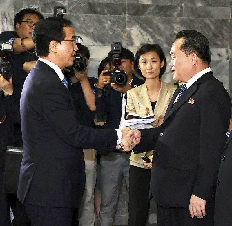 Cho Myoung-gyon (left), South Korea’s Unification minister, shakes hand with his North Korean coun- terpart Ri Son Gwon before leaving for South Korea after their meeting Monday at the northern side of Panmunjom in the Demilitarized Zone. The two sides announced their leaders will meet in September.