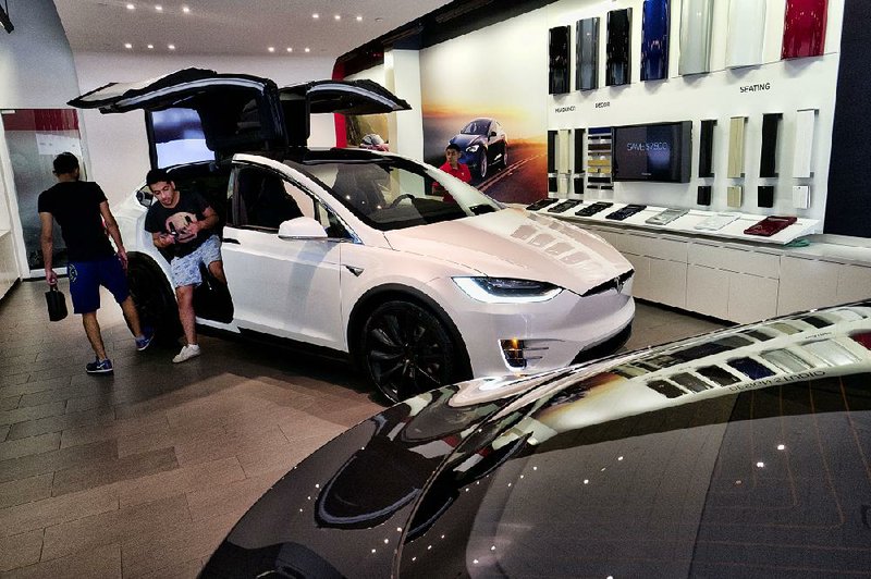 Customers check out the Tesla X at the Tesla showroom last week in Santa Monica, Calif. Tesla CEO Elon Musk said Monday that Saudi Arabia’s sovereign wealth fund would be the main source of money in a plan to take the company private.