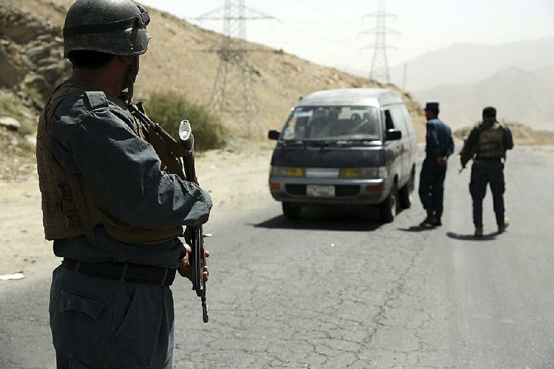 Afghan police officers search a vehicle at a checkpoint on the Ghazni highway, in Maidan Shar, west of Kabul, Afghanistan, on Monday.