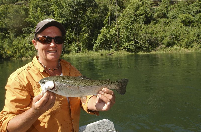 Lisa Mullins, a White River fishing guide, shows a rainbow trout she caught below Beaver Dam in 2009. 