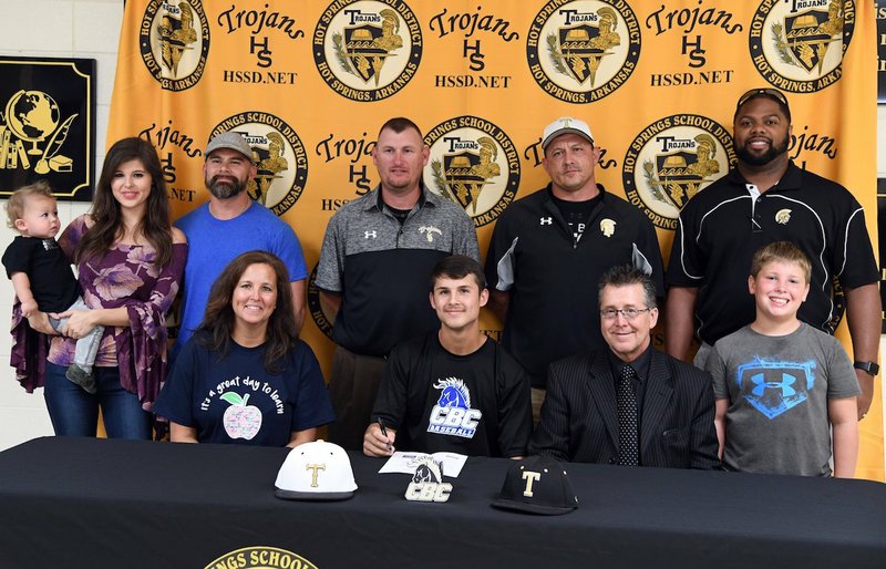 The Sentinel-Record/Grace Brown TROJAN SIGNING: Hot Springs' Ben Slate, center, signed a letter of intent on Wednesday to play baseball for Central Baptist College in Conway. He was accompanied at Hot Springs World Class High School, in front, from left by his mother, Robin Slate; father, David Slate; and Mark Lusher; and back, from left, Gabriel Dankert, Ashley Dankert, Daniel Dankert, coach Brandon Bates, coach Kurk Wasson and Hot Springs Athletic Director Rodney Echols.