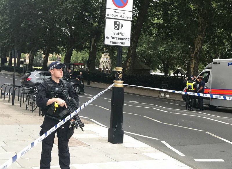 Police patrol on Millbank, in central London, after a car crashed into security barriers outside the Houses of Parliament, in London, Tuesday, Aug. 14, 2018. London police say that a car has crashed into barriers outside the Houses of Parliament and that there are a number of injured. (Sam Lister/PA via AP)

