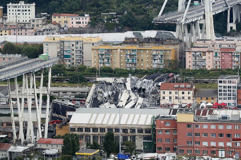 A lone truck sits at the edge of part of a highway bridge that collapsed during a severe storm Tuesday in Genoa, Italy, sending rubble and dozens of vehicles plunging nearly 150 feet. At least 26 people were killed. At least four survivors were found.