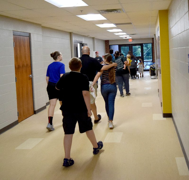 Westside Eagle Observer/MIKE ECKELS A group of students and parents walk down the new hallway leading to the Decatur Middle School office during the district's open house Aug. 9.