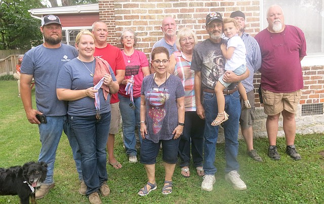 Westside Eagle Observer/SUSAN HOLLAND Winners in the sixth annual Gravette Day Dutch oven cook-off pose with their medals after competition awards were presented. Pictured are All Fired Up, Corey and Donna Taylor and Dax, third place winners; Pot Rasslers Kelley Sharp, Jane Beek and Jesse Beek, first place winners; Marilyn Munger, Margie and Marvin VanNoy and Emersyn, first place novice winners; and Culvercreek Posse, Jon and Jarren Tupper, second place winners.