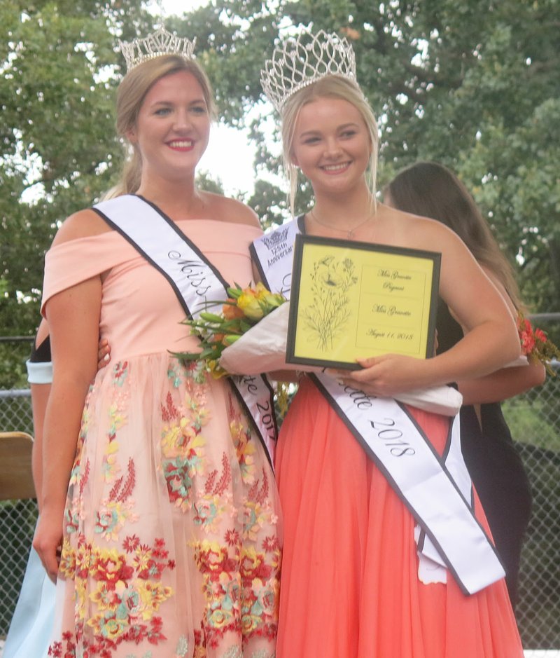 Westside Eagle Observer/SUSAN HOLLAND Isabella Dell, Miss Gravette 2017, poses with Darlene McVay, the newly crowned Miss Gravette 2018, at the conclusion of the Miss Gravette pageant Saturday evening. McVay was also chosen Miss Congeniality and was first in the evening gown and interview competitions.