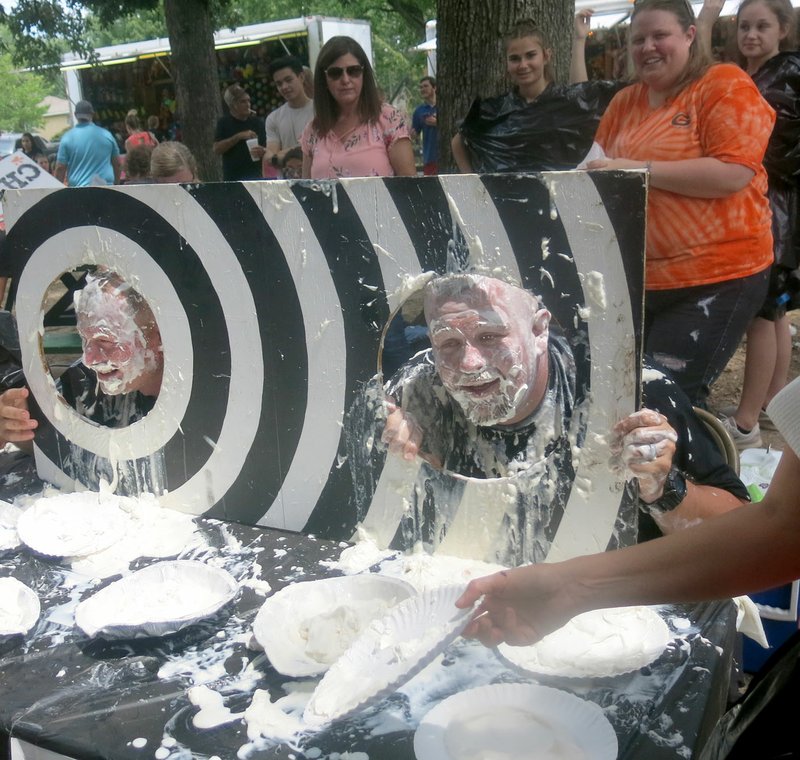 Westside Eagle Observer/SUSAN HOLLAND Adam Vore, Gravette coach and middle school teacher, and officer Josh Crane, one of Gravette's school resource officers, still have grins on their faces after being hit with several pies. The &quot;pie in the face&quot; booth in Kindley Park at Saturday's Gravette Day event was a popular fundraiser for the junior high cheerleaders.