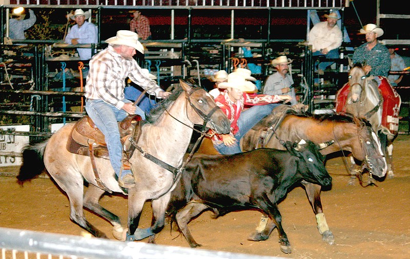 MARK HUMPHREY ENTERPRISE-LEADER A cowboy makes a daring leap from horseback to get hold of a steer and wrestle the animal to the ground during Saturday night's final performance at the 65th annual Lincoln Rodeo.