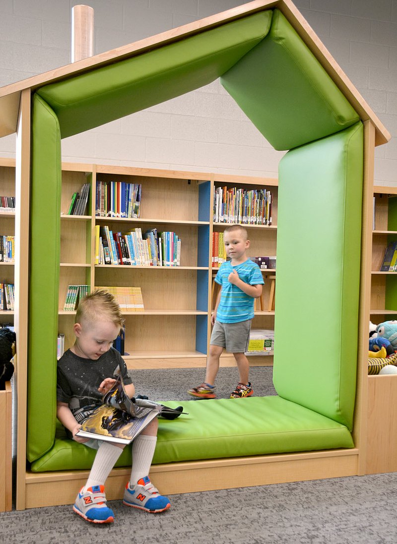 Janelle Jessen/Herald-Leader Jude Grass read in one of the many reading nooks in the recently completed Northside Elementary School Library as Rush Harris looked on. Both boys were waiting while their older siblings completed the school's open house for kindergarten students on Monday afternoon.