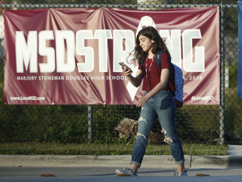 A student walks past an &quot;MSDSTRONG&quot; banner on the way to class at Marjory Stoneman Douglas High School, Wednesday, Aug. 15, 2018, in Parkland, Fla. Students returned to a more secure campus as they began their first new school year since a gunman killed 17 people in the freshman building. (AP Photo/Wilfredo Lee)