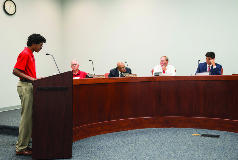 MHS student Terrell Page (standing) addresses the Magnolia School Board of Education Monday evening. Page, a AAA Advisory Board member, recently attended a national leadership conference. Also pictured (sitting, L-R) are: School Board members Roger Loper, William Watson, President Mike Waters, and Superintendent John Ward.