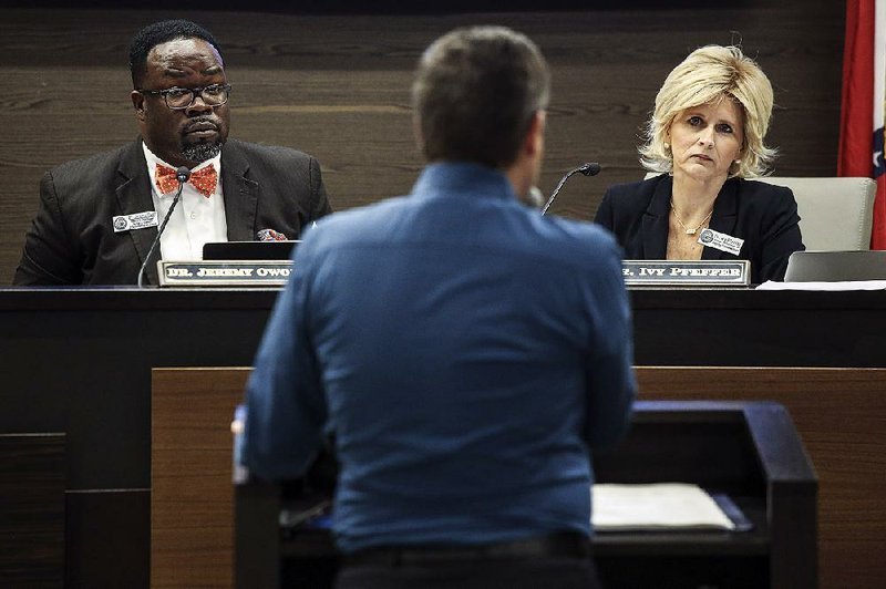 State Department of Education officials Jeremy Owoh and Ivy Pfeffer listen Wednesday to Dan Fushee of Focus Academy of Arts and Sciences in Bentonville during a Charter Authorizing Panel meeting in Little Rock.  