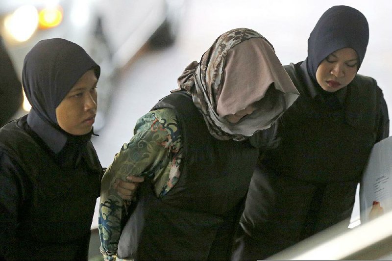 Vietnamese Doan Thi Huong, center, is escorted by police as she arrives for a court hearing at Shah Alam High Court in Kuala Lumpur, Malaysia, Thursday, Aug. 16, 2018. 