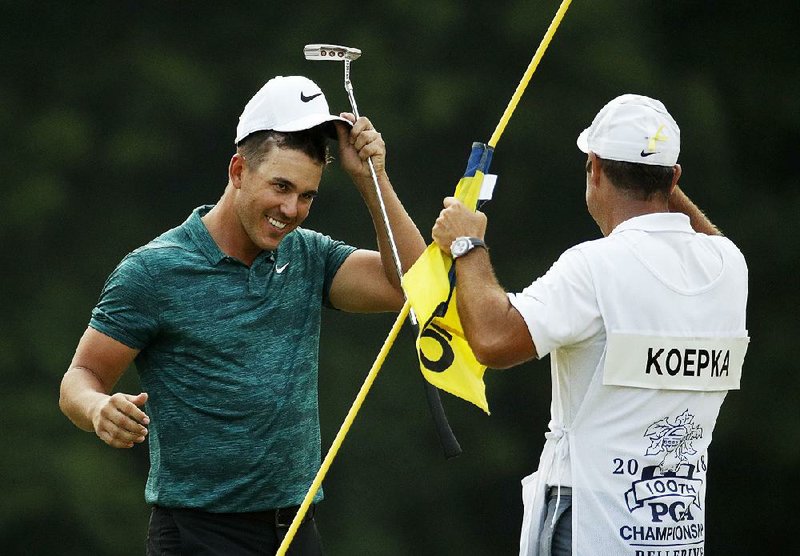 Brooks Koepka (left) celebrates with caddie Ricky Elliott after Koepka won the PGA Championship at Bellerive Country Club in St. Louis on Sunday.  