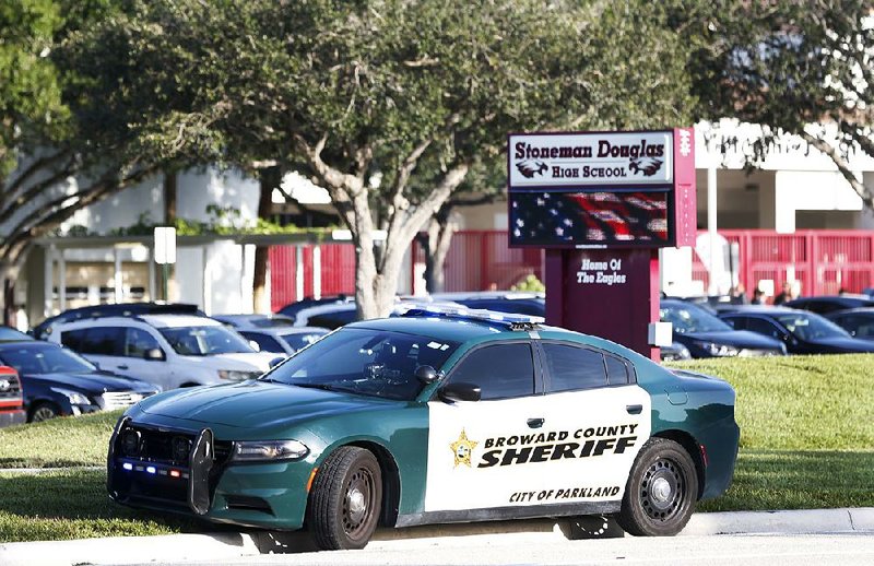 A patrol car sits Wednesday outside Marjory Stoneman Douglas High School in Parkland, Fla., as students return to class for a new school year.  