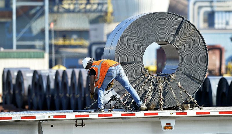 A truck driver secures a roll of steel to his flatbed at the Nucor Corp. steel plant in Ghent, Ky., last month.  
