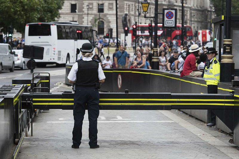 Police secure the area near a road barrier Wednesday outside the Houses of Parliament in London the day after a suspected terror attack.  