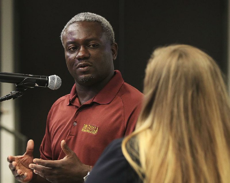Dedrick Sims with the Sims-Fayola International Academy in Pine Bluff answers questions Thursday for Arkansas Department of Education attorney Mary Claire Hyatt during a Charter Authorizing Panel meeting in Little Rock. The panel voted to deny a charter for the school. 