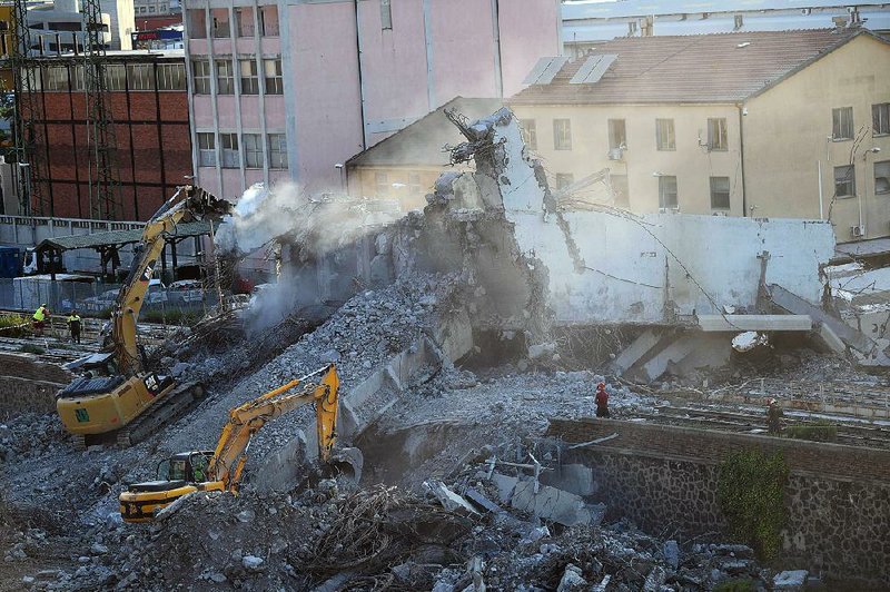 Workers remove rubble Thursday from the Morandi bridge that collapsed earlier this week in Genoa, Italy.  