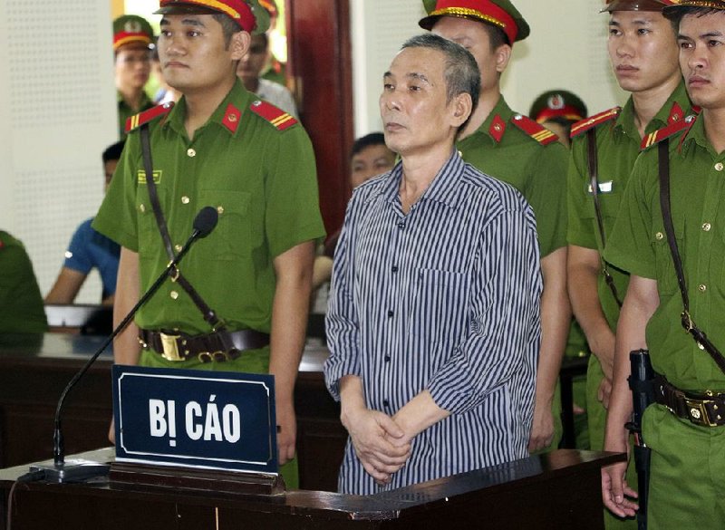 Activist Le Dinh Luong (center) stands for sentencing Thursday in the central province of Nghe An, Vietnam.  
