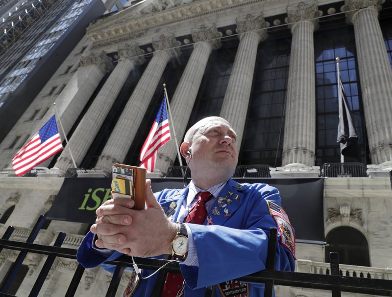 In this April 26, 2018, file photo, Vincent Pepe enjoys some fresh air outside the New York Stock Exchange where he works trading cotton shares for VLM Commodities in the Financial District in New York. 