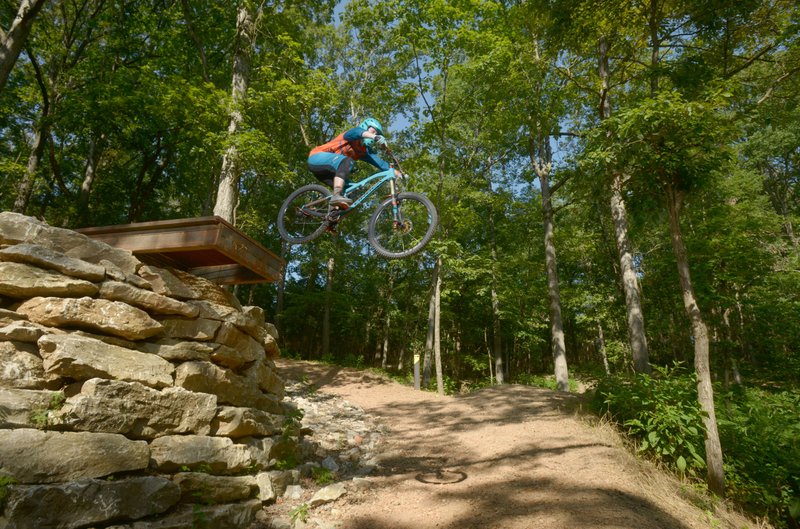 Jordan Sauls of Centerton launches off a drop on the Drop the Hammer trail Thursday, July 20, 2017, at Coler Preserve in Bentonville.