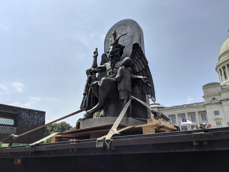 The Satanic Temple unveils its statue of Baphomet, a winged-goat creature, at a rally for the first amendment in Little Rock on Thursday. The Satanic Temple wants to install the statue on Capitol grounds as a symbol for religious freedom after a monument of the Biblical Ten Commandments was installed in 2017. (AP Photo/Hannah Grabenstein)
