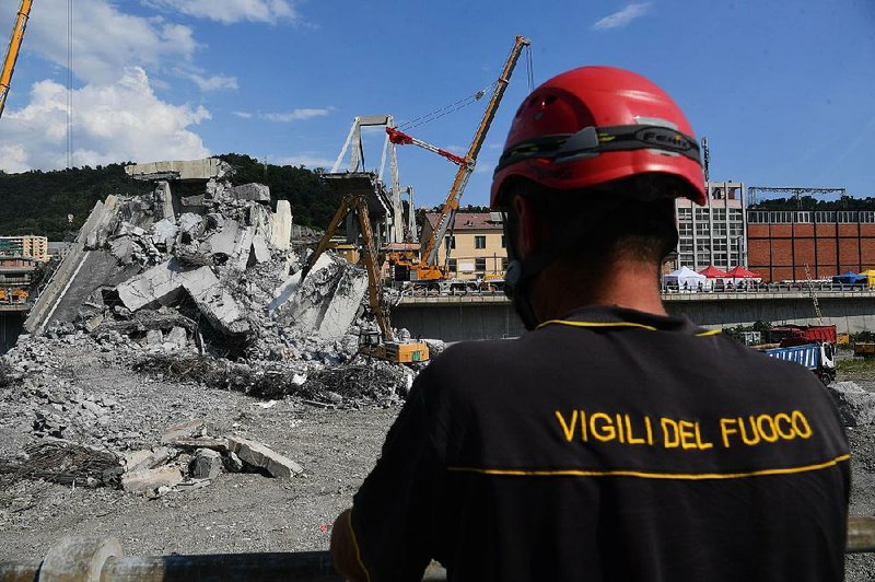 A firefighter watches on Friday as debris is cleared from the collapsed Morandi Bridge in Genoa, Italy. 