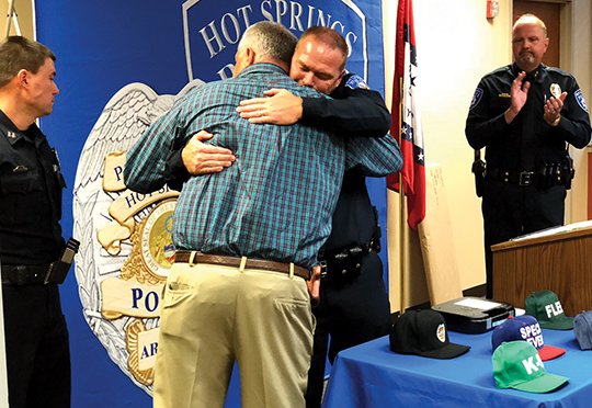 The Sentinel-Record/Mark Gregory FAREWELL: Capt. Walt Everton, on the left, embraces retiring Hot Springs Assistant Police Chief Chris Chapmond on Friday during a ceremony at the Hot Springs Police Department as Hot Springs Police Chief Jason Stachey, right, and Capt. Billy Hrvatin, left, watch.