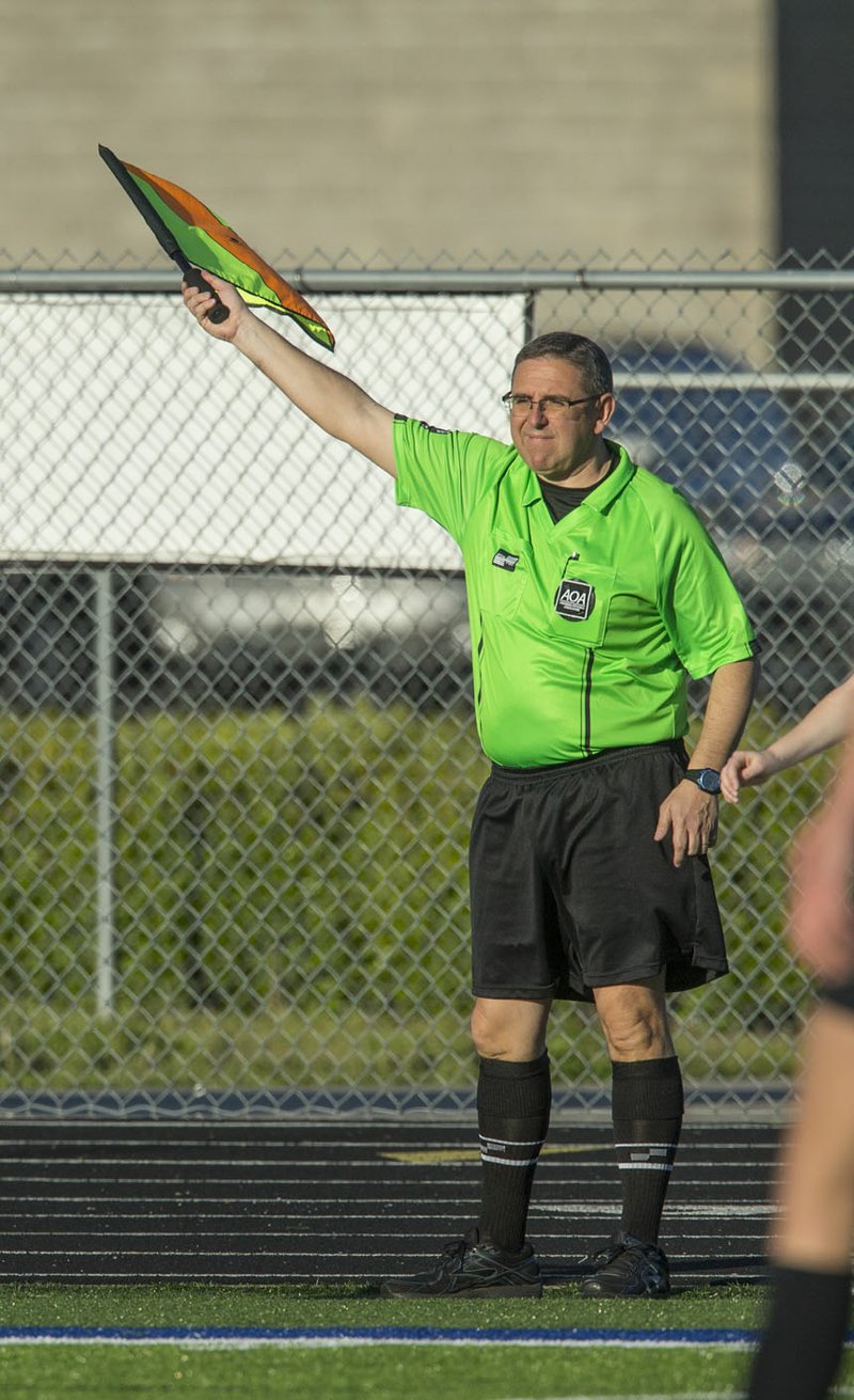 NWA Democrat-Gazette/BEN GOFF  @NWABENGOFF Angel Diaz signals while working the assistant referee position April 27 during the girls match between Bentonville and Rogers at Whitey Smith Stadium in Rogers.