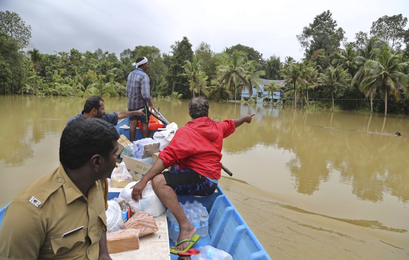 Volunteers travel in a boat with essential supplies for stranded people in a flooded area in Chengannur in the southern state of Kerala, India, Sunday, Aug.19, 2018. Some 800,000 people have been displaced and over 350 have died in the worst flooding in a century. (AP Photo/Aijaz Rahi)