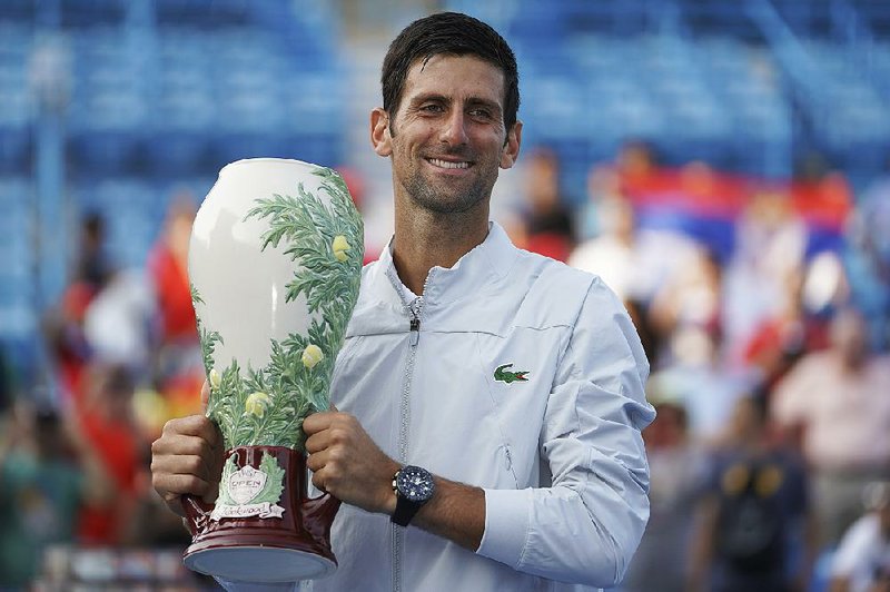 Novak Djokovic, of Serbia, holds the Rookwood Cup after defeating Roger Federer, of Switzerland, during the finals at the Western & Southern Open tennis tournament, Sunday, Aug. 19, 2018, in Mason, Ohio.