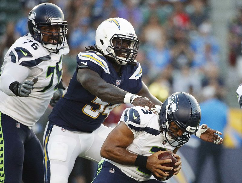 Los Angeles Chargers defensive end Melvin Ingram (left) defends against Seattle Seahawks quarterback Russell Wilson during the first half Saturday in Carson, Calif. Ingram made the game anything but enjoyable for Wilson by getting into the backfield seemingly at will.