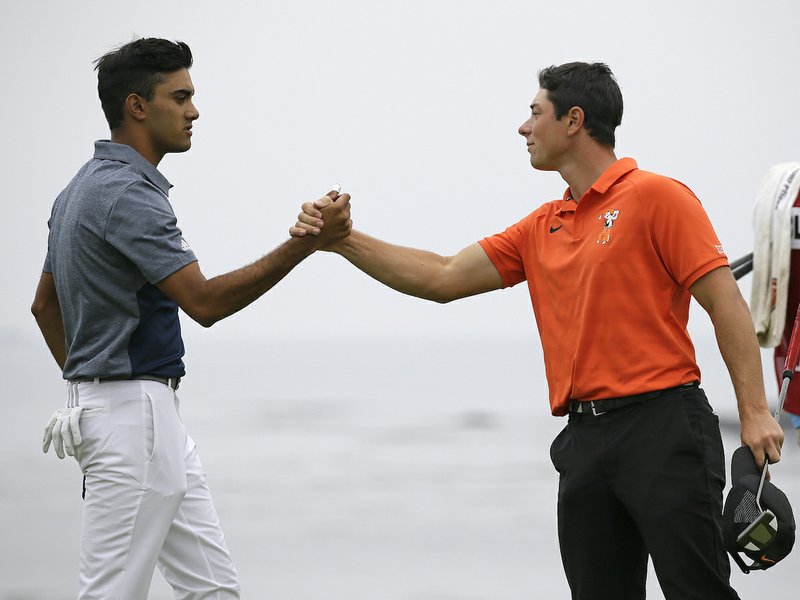 Viktor Hovland, right, of Norway, is greeted by Devon Bling, left, on the 18th green of the Pebble Beach Golf Links during the final round of the USGA Amateur Golf Championship Sunday, Aug. 19, 2018, in Pebble Beach, Calif. (AP Photo/Eric Risberg)