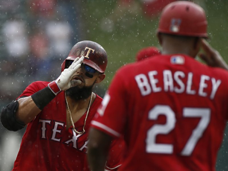 Texas Rangers' Rougned Odor is congratulated by third base coach Tony Beasley (27) after he hit a three-run home run during the seventh inning of a baseball game Sunday, Aug. 19, 2018, in Arlington, Texas. (AP Photo/Mike Stone)