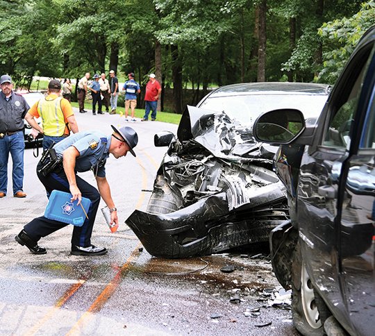 The Sentinel-Record/Grace Brown- Cpl. Brandon Margis with Arkansas State Police marks the tires of a Nissan Versa involved in a two-vehicle fatal accident between the Nissan and a Chevrolet Silverado that occurred in the 600 block of Brady Mountain Road shortly after 5:30 p.m. on Sunday, August 19, 2018. According to Cpl. Margis, the passenger of the Nissan was declared dead on arrival and the driver was transported to an area hospital by the LifeNet helicopter. The driver was transported to an area hospital by LifeNet ambulance.