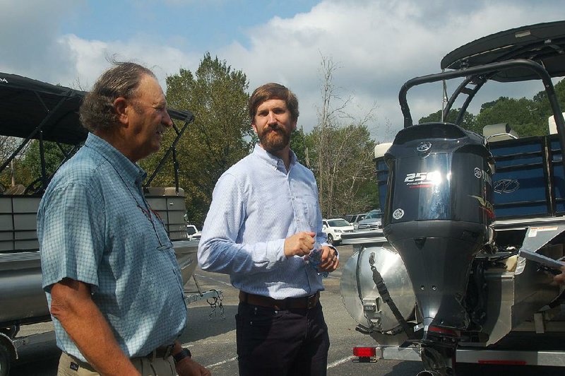 Rodney Herndon (left) and son Rory on Monday discuss the expansion of Veranda Luxury Pontoons at the Hot Spring County Industrial Park near Malvern. 