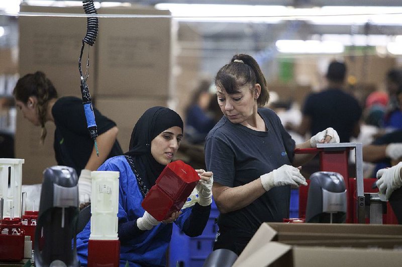 Employees work at the SodaStream factory near Rahat, Israel. Beverage giant PepsiCo has bought the Israeli maker of carbonated drink machines for $3.2 billion. 