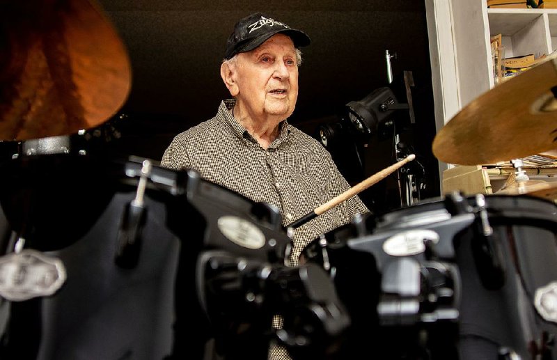 Joe Holland sits behind a kit at his Little Rock home. The 90-year-old Holland has been drumming most of his life.