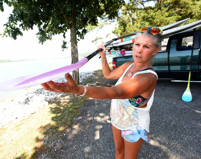 NWA Democrat-Gazette/FLIP PUTTHOFF Melody Elliott shows a bent shaft that is typical of most stand-up paddle board paddles.