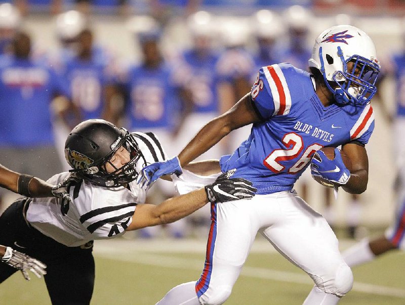 West Memphis running back Rodney Doby (right) tries to elude a Little Rock Central defender Tuesday during the Blue Devils’ 35-0 victory over the Tigers at War Memorial Stadium in Little Rock. For more photos, visit arkansasonline.com/galleries. 