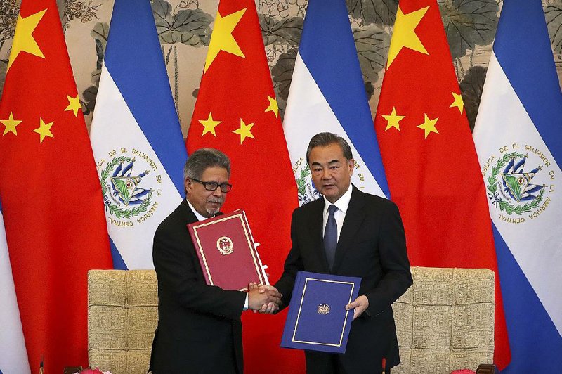 Salvadoran Foreign Minister Carlos Castaneda (left) and Chinese Foreign Minister Wang Yi hold a signing ceremony Tuesday in Beijing marking the opening of diplomatic relations. The signing prompted Taiwan to sever ties with El Salvador. 