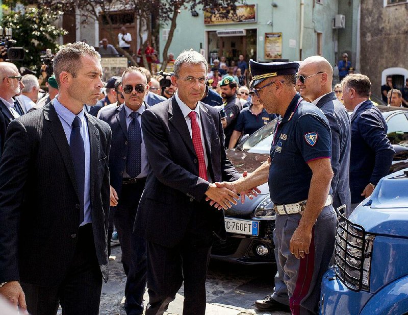Italian environment minister Sergio Costa (center) visits flood-devastated Civita in southern Italy on Tuesday. 