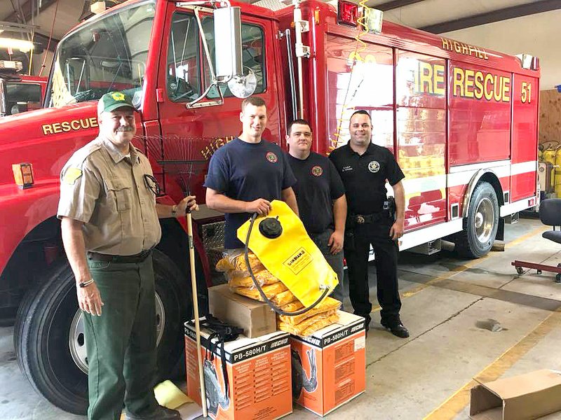 SUBMITTED The Highfill Fire Department received Wildfire Suppression Kits from The Arkansas Forestry Commission. These kits contain valuable equipment to help protect firefighters and extinguish wildfires. The department was chosen as one of the 2018 recipients. Fire Chief Gene Holland (center) reported on the grant at the city council meeting Aug. 14.