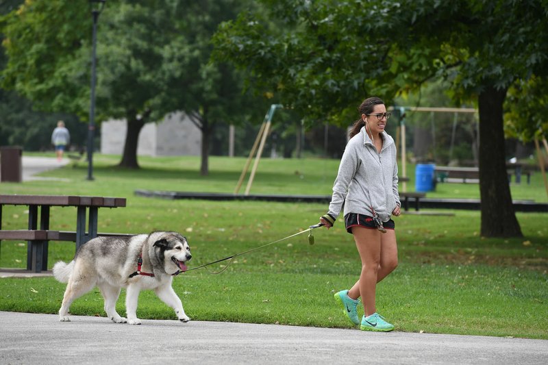 NWA Democrat-Gazette/J.T. WAMPLER Ashley Robinson of Springdale walks her dog Abbey in Murphy Park on Tuesday in Springdale. Robinson comes to Murphy park fairly often to walk Abbey.