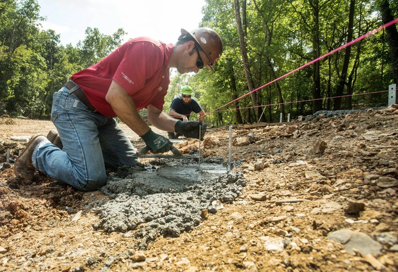 NWA Democrat-Gazette/BEN GOFF  @NWABENGOFF TJ LaPlant (left) and Jeff Cargile with Crossland Construction set footings for a boardwalk Tuesday at Coler Mountain Bike Preserve in Bentonville. Crossland is working on a new trailhead and pavilion on Northwest Third Street and hard-surface greenway through the park connecting to the parking lot on Peach Orchard Road.