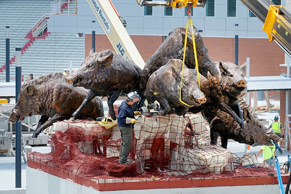 Work continues Monday, Aug. 6, 2018, on the installation of the "Wild Band of Razorbacks" monument outside Donald W. Reynolds Razorback Stadium in Fayetteville. 