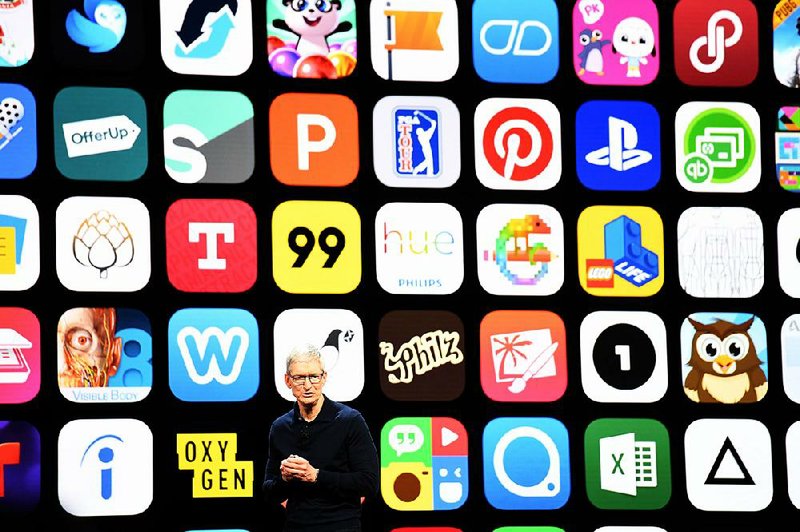 Apple Inc. CEO Tim Cook speaks earlier this year at a developers conference in San Jose, Calif. Apple and Google launched their app stores in 2008 and now charge commissions of up to 30 percent of what consumers pay developers. 